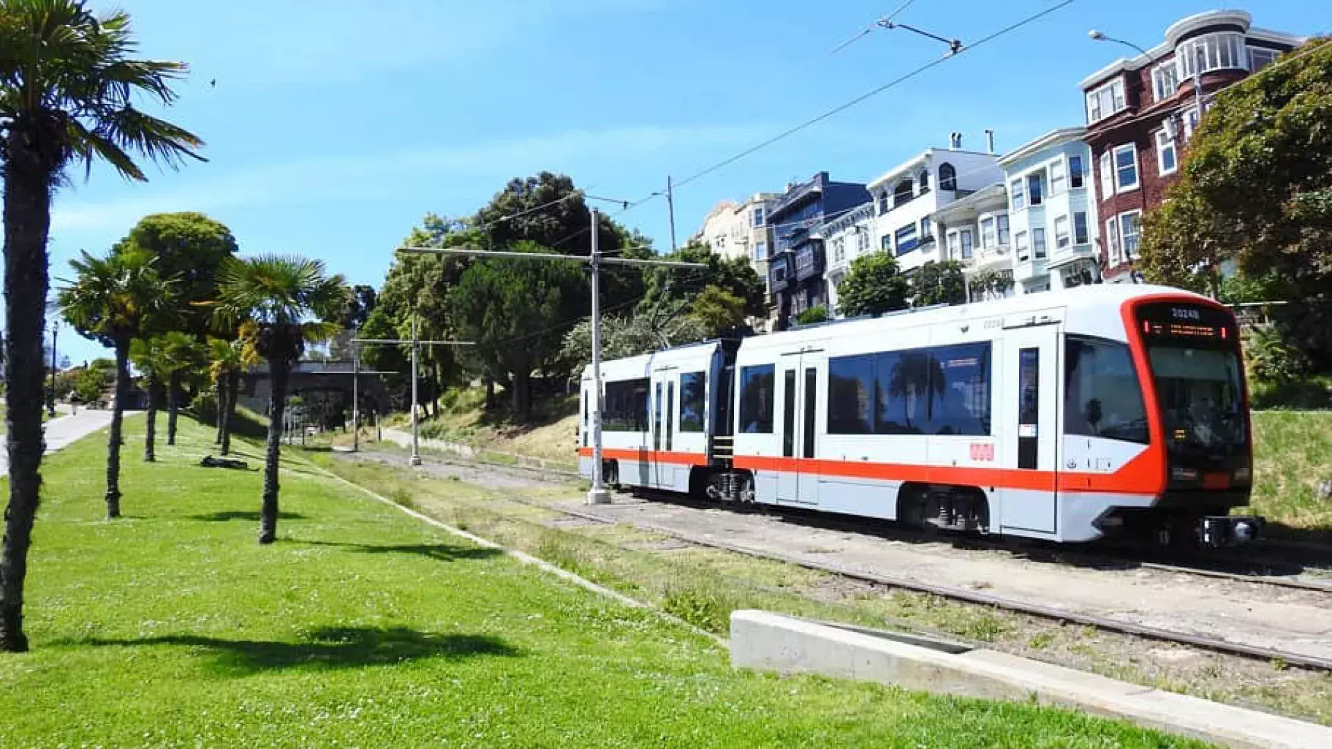 A MUNI passenger train runs along a track in San Francisco.