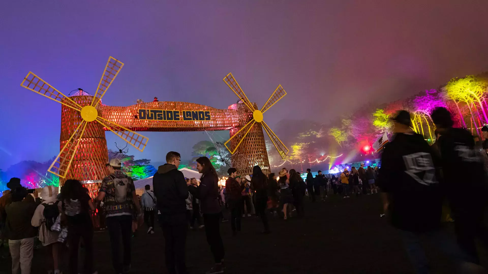 Uma multidão de festivaleiros é fotografada à noite em meio a luzes de néon no festival de música Outside Lands, em São Francisco.