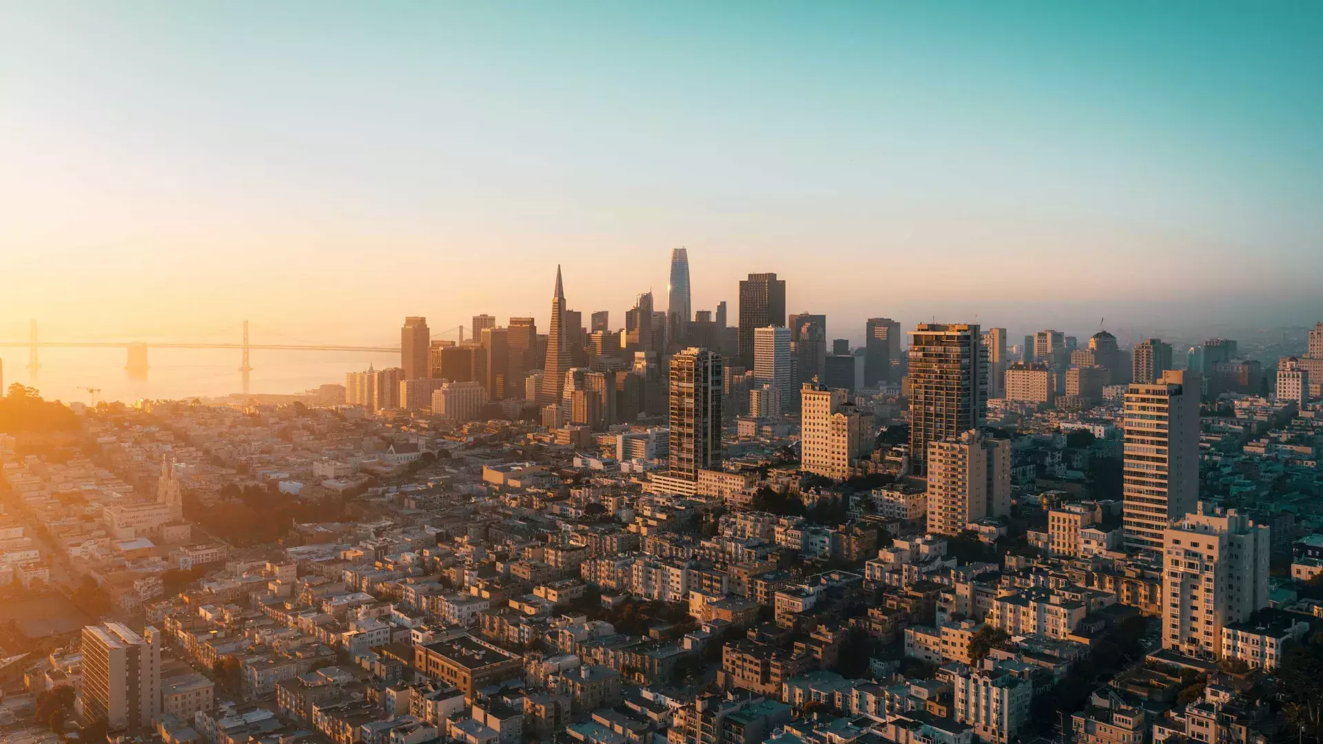 The skyline of San Francisco is seen from the air in a golden light.