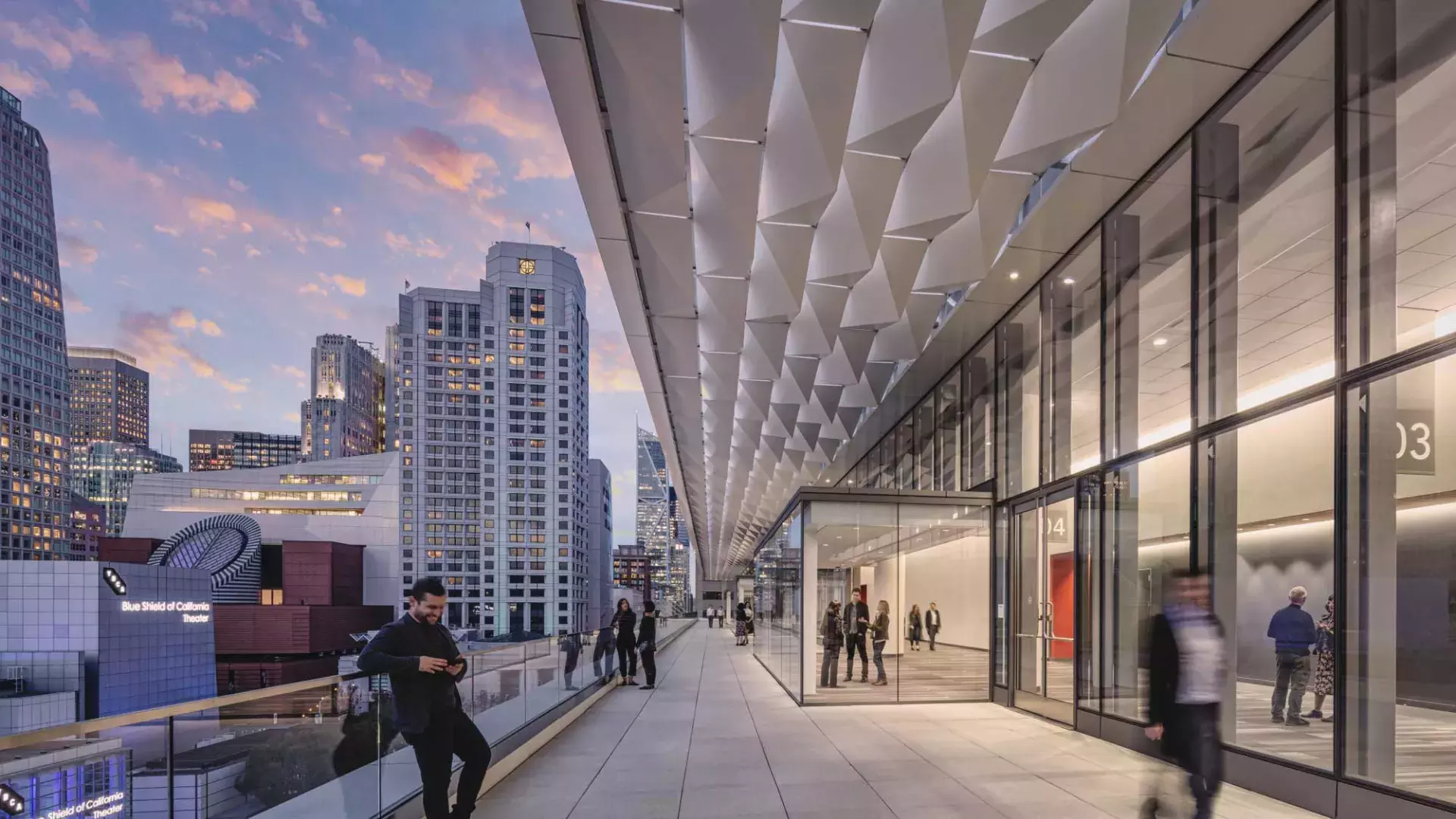 Meeting attendees stand and stroll on a balcony at Moscone Center South in San Francisco.