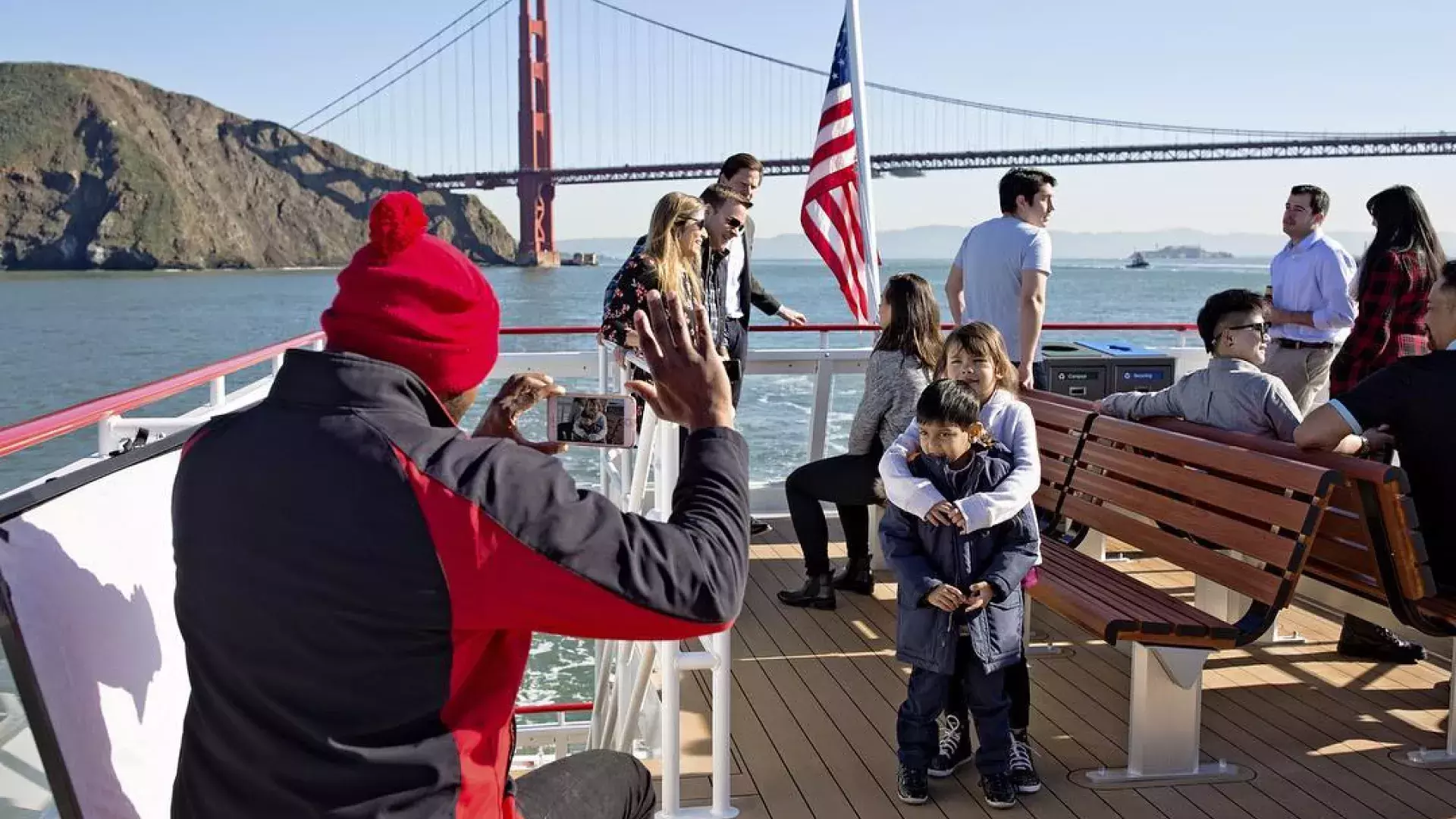 A family enjoys a cruise on the bay, passing the Golden Gate Bridge.