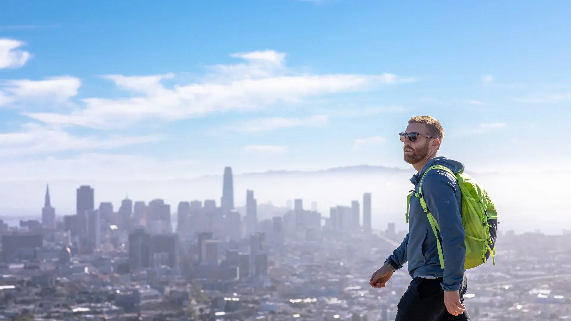 A visitor hikes to the top of Twin Peaks with his backpack.