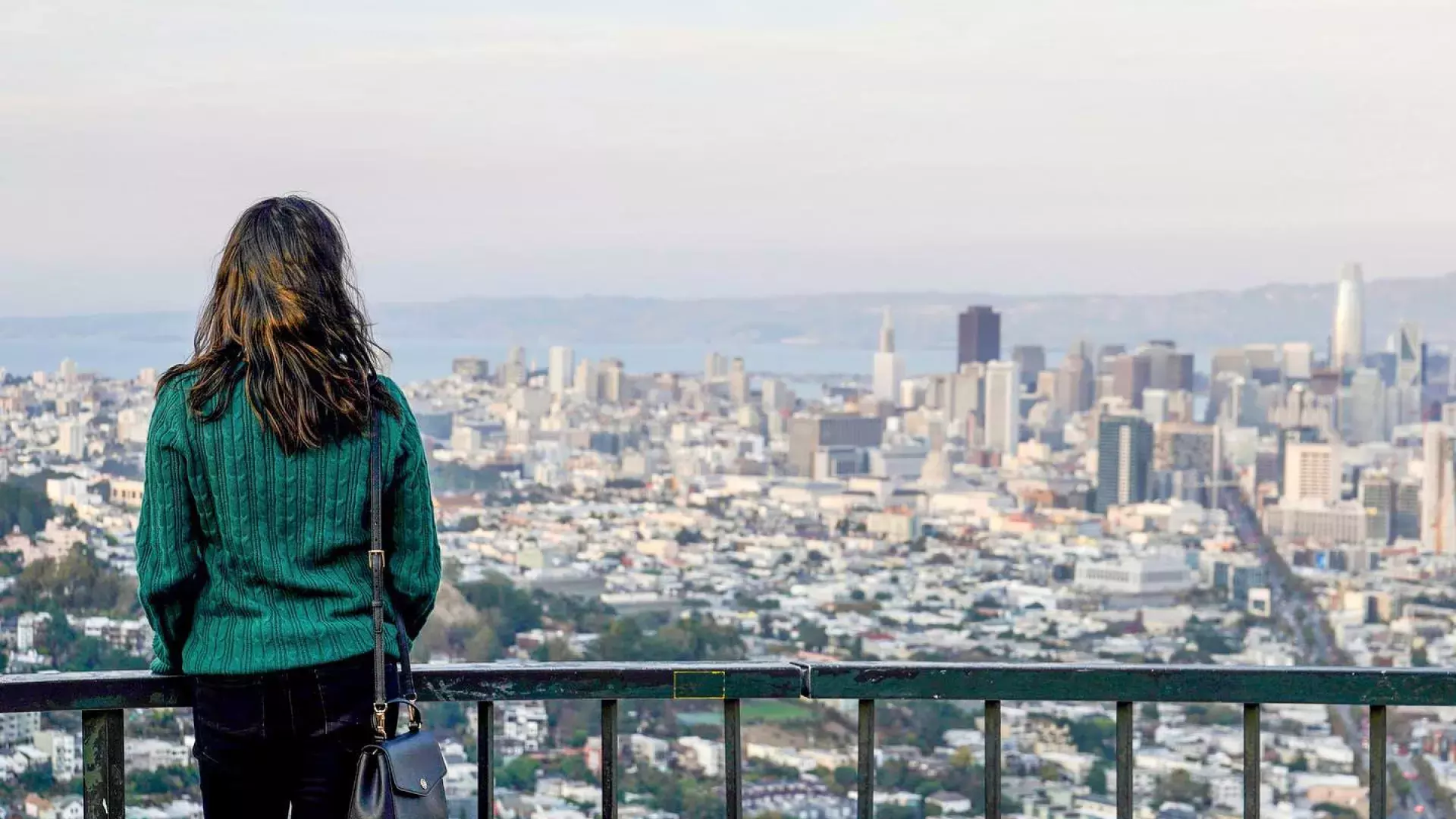 A woman looks at the San Francisco skyline from Twin Peaks.