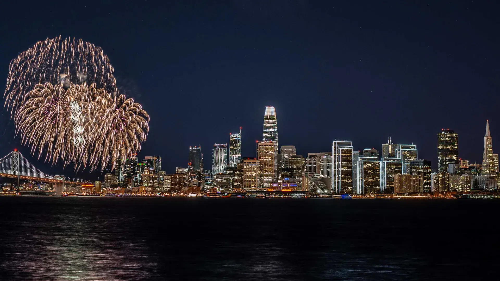Fireworks explode over the San Francisco city skyline.