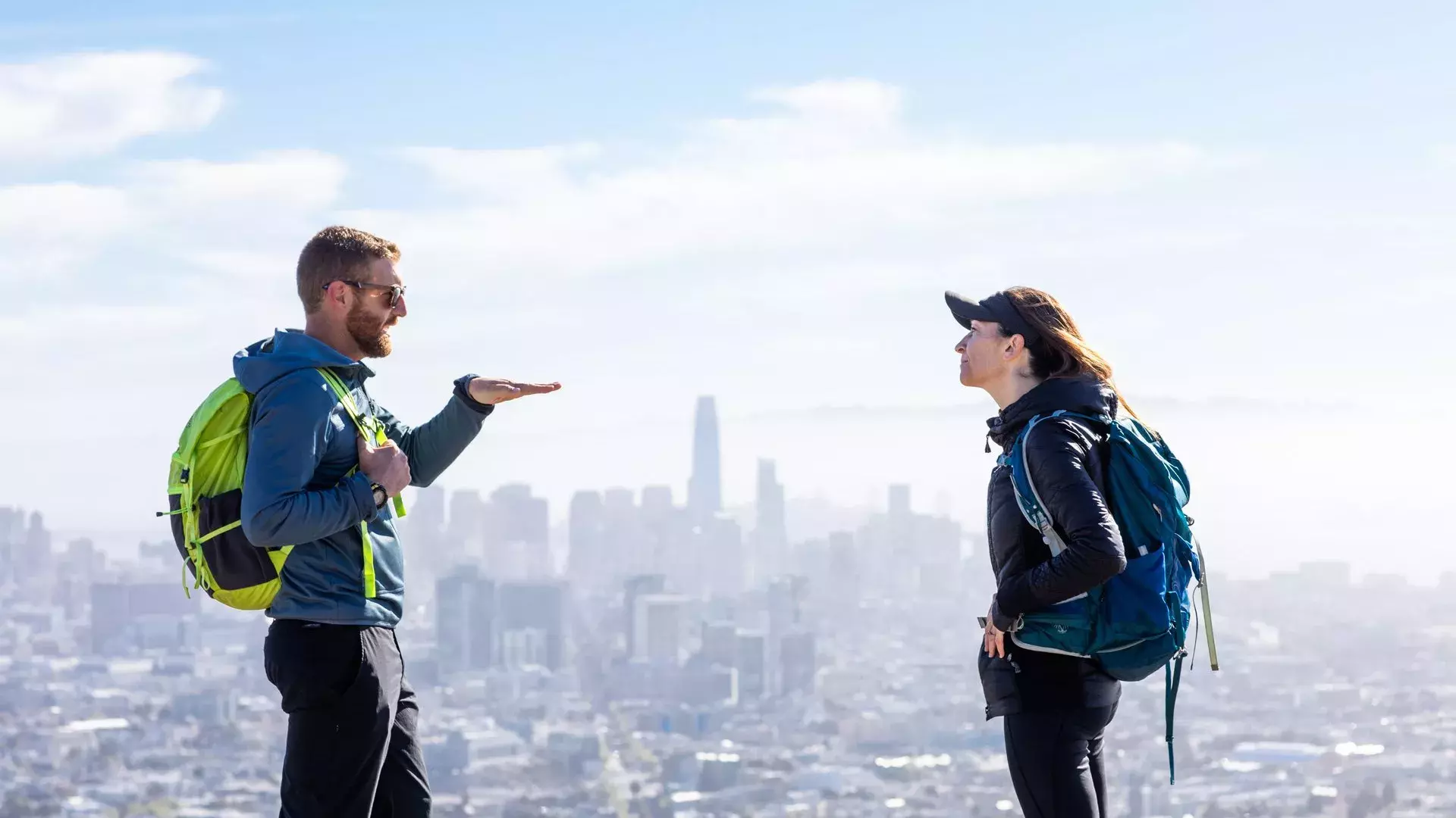 Hikers chatting with the San Francisco skyline in the distance