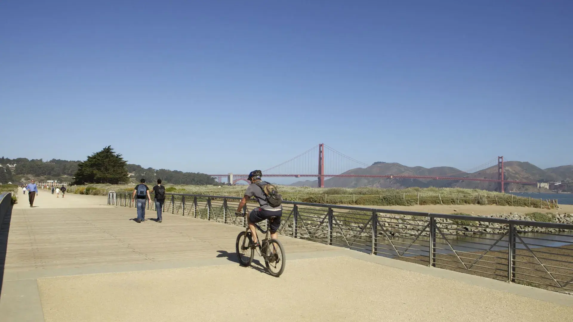 A man rides a bike along a trail at Crissy Field. San Francisco, California.