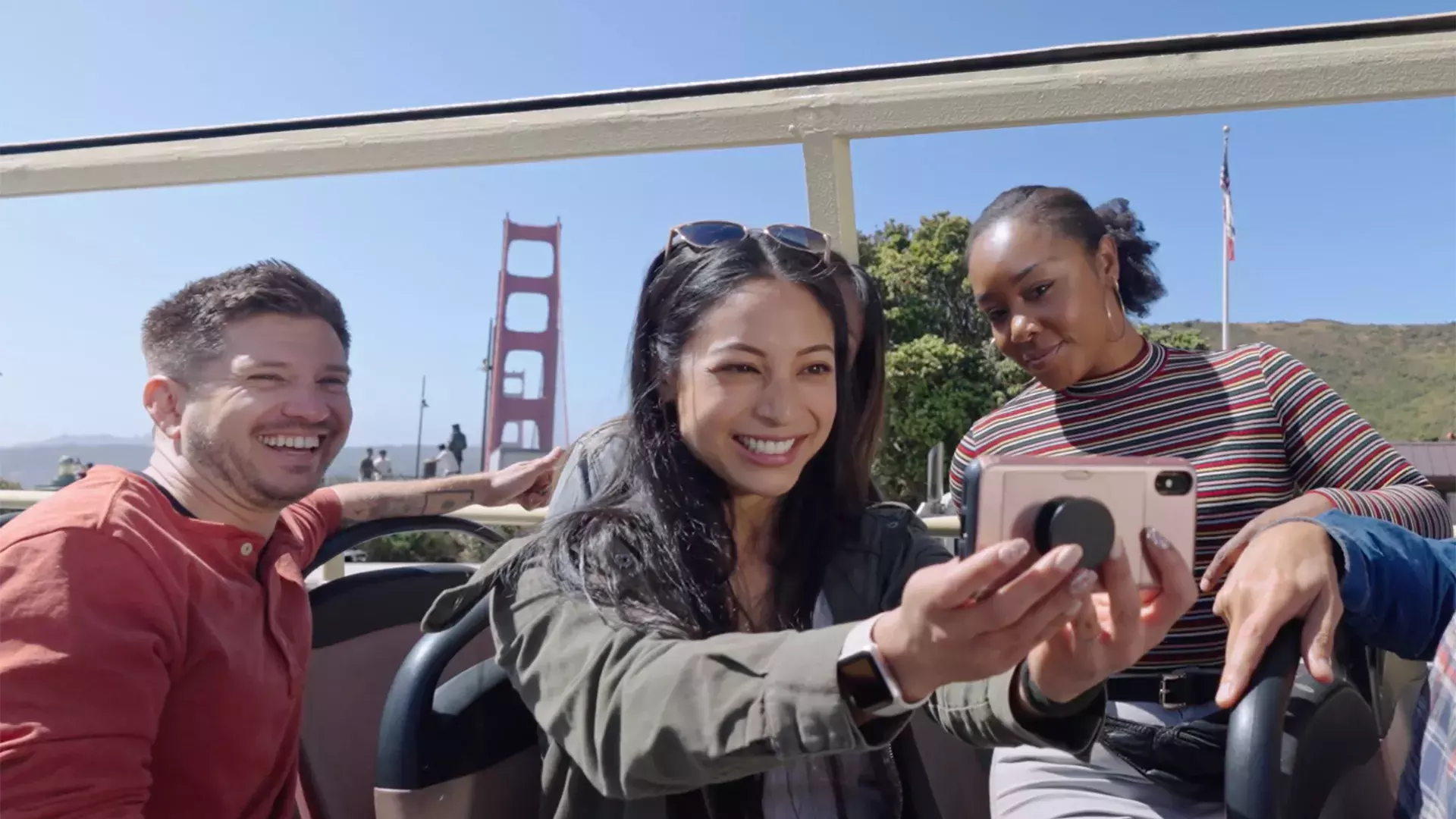 A group of visitors take a selfie on a bus tour near the Golden Gate Bridge. San Francisco, CA.