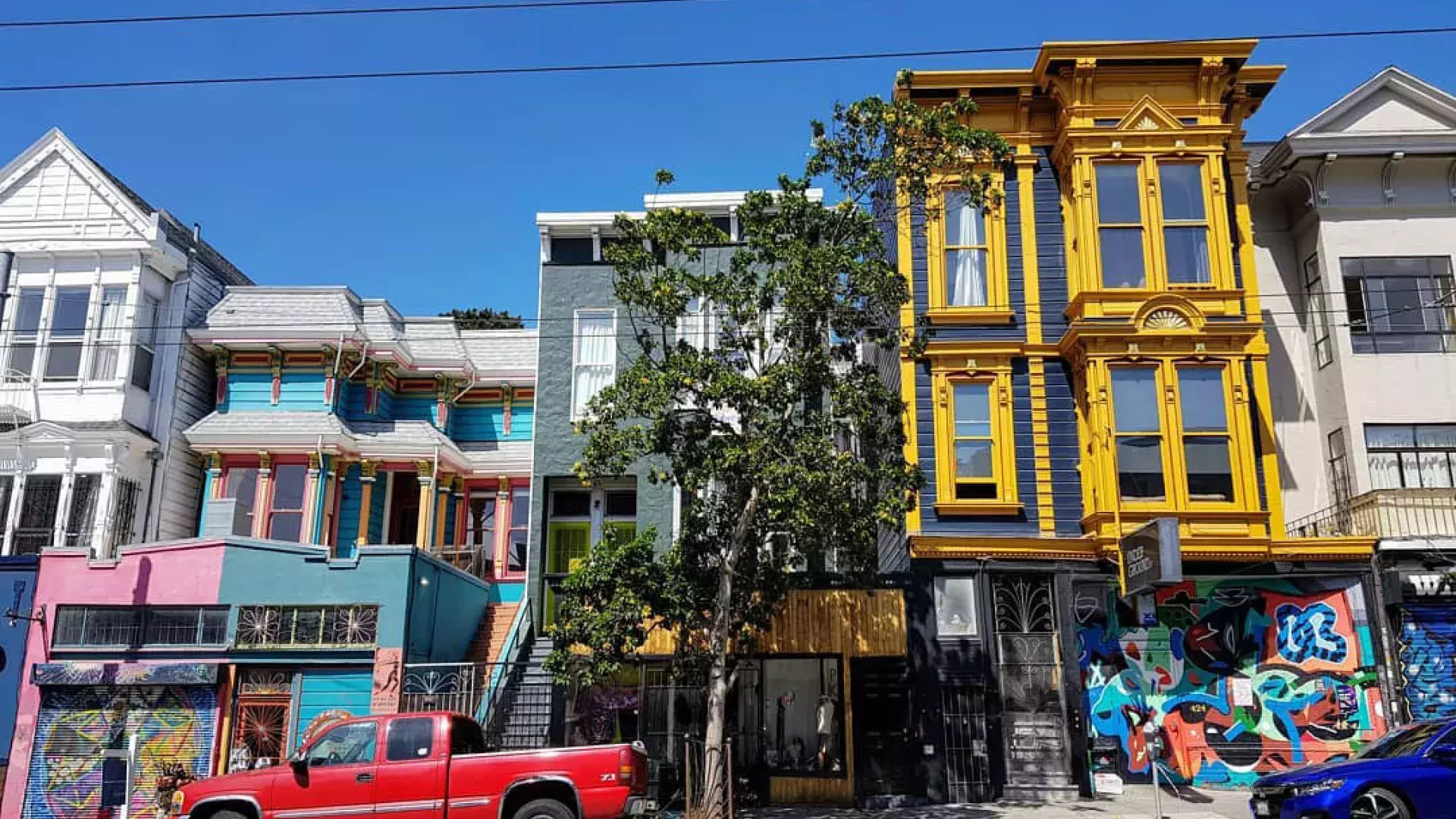 View of colorful buildings on Haight Street with cars parked along the street. San Francisco, California.