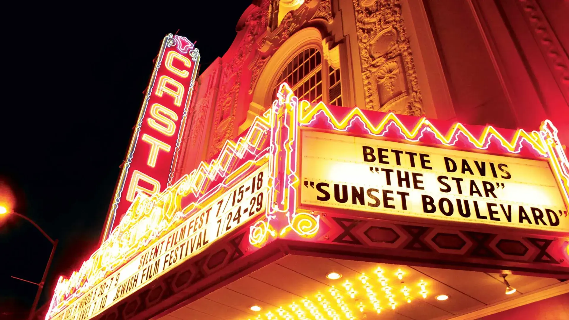 The neon marquee and sign for the Castro Theatre is lit up at night.