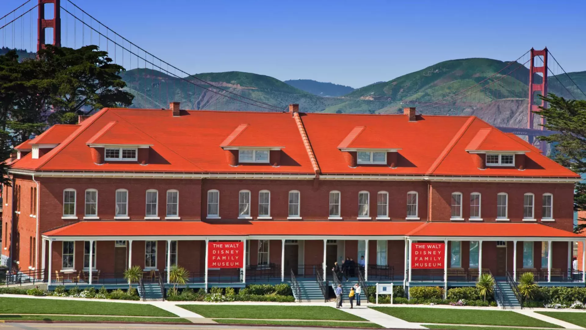 The Walt Disney Family Museum, housed in a row of red-brick former barracks, stands in front of the Golden Gate Bridge. San Francisco, California.