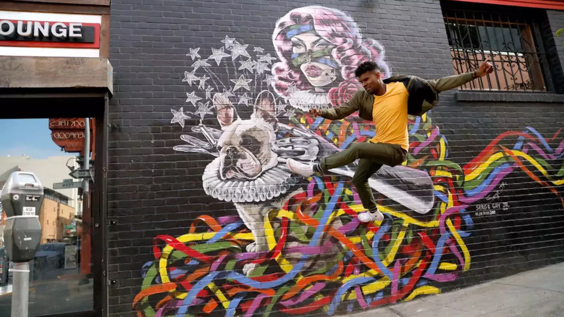 Artist Serge Gay Jr. in front of one of his many murals.