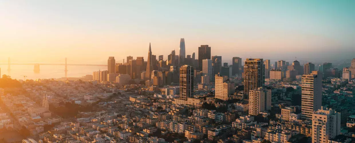 The skyline of San Francisco is seen from the air in a golden light.