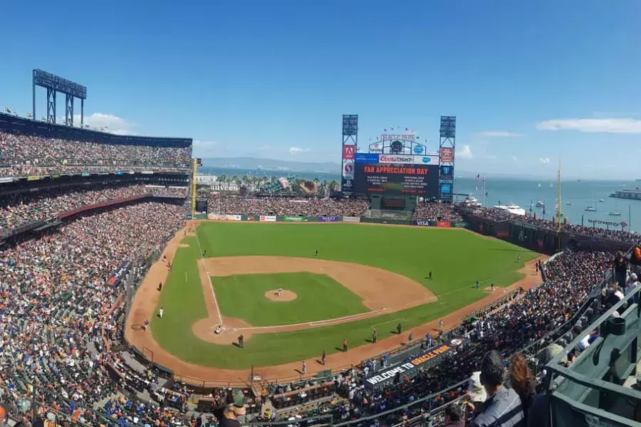 A view of San Francisco's Oracle Park looking out from the stands, with the baseball diamond in the foreground and San Francisco Bay in the background.