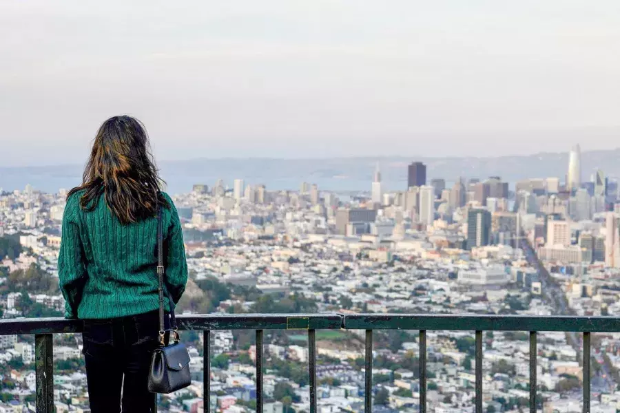 A woman looks at the San Francisco skyline from Twin Peaks.