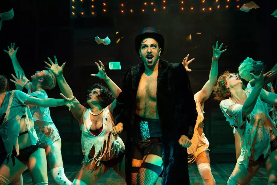 Performers try to catch floating money on stage during a production of Cabaret at the San Francisco Playhouse.