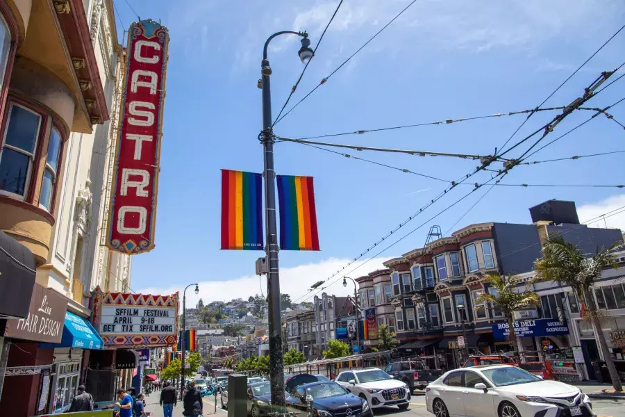 O bairro Castro, em São Francisco, com a placa do Teatro Castro e bandeiras arco-íris em primeiro plano.