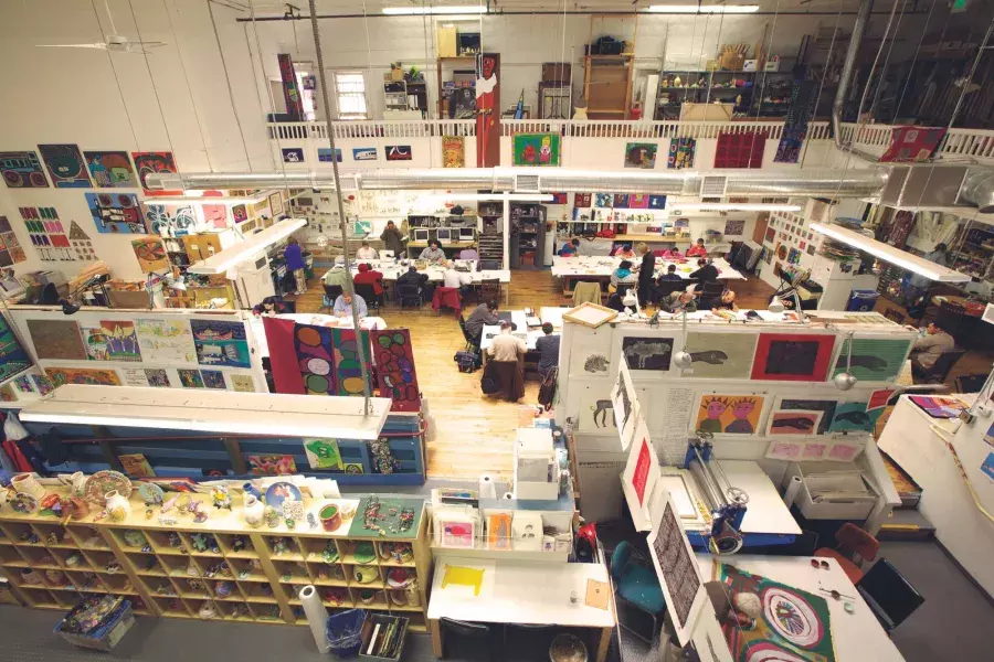 The floor of Creativity Explored, with an assortment of desks and works of art, seen from overhead.