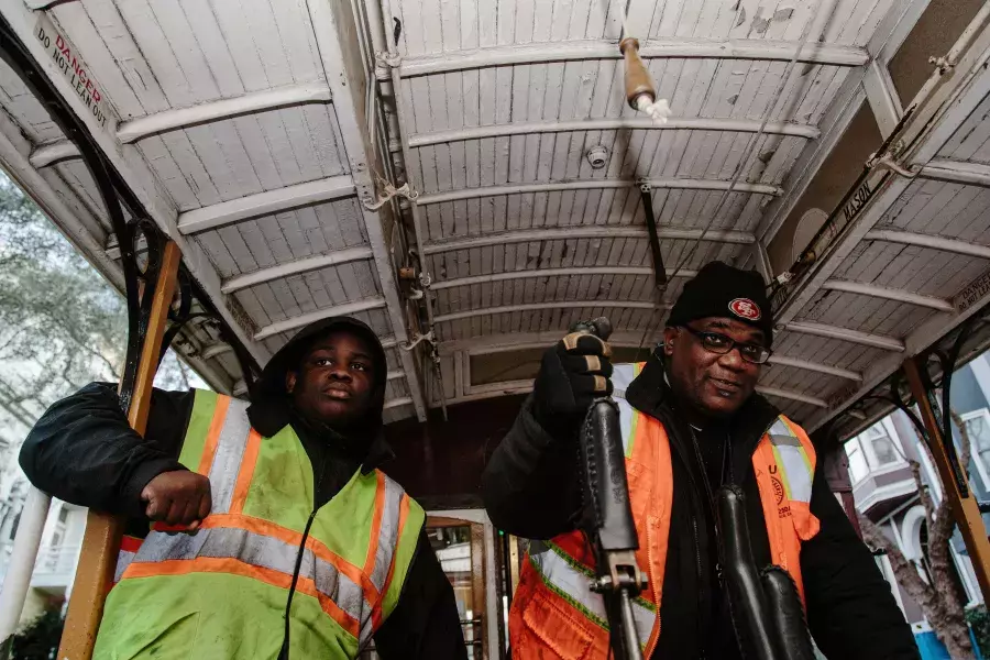 Ellis Cato and his son driving a cable car.