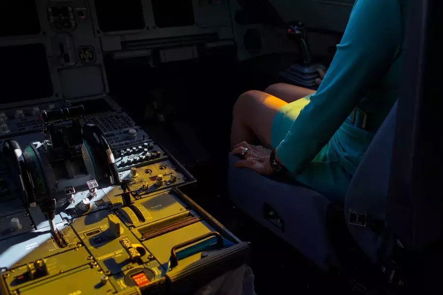 Hands near controls in the cockpit.