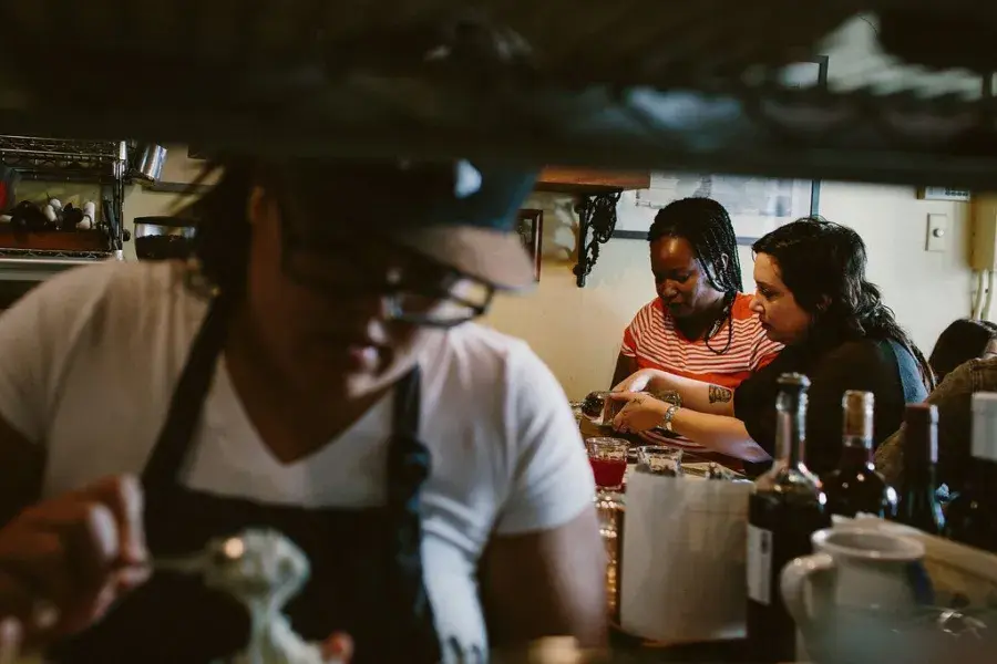 View from the kitchen of diners eating.
