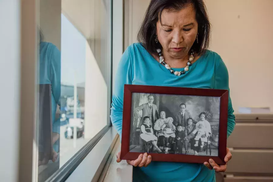 Melinda Yee Franklin holding a photograph of her family.