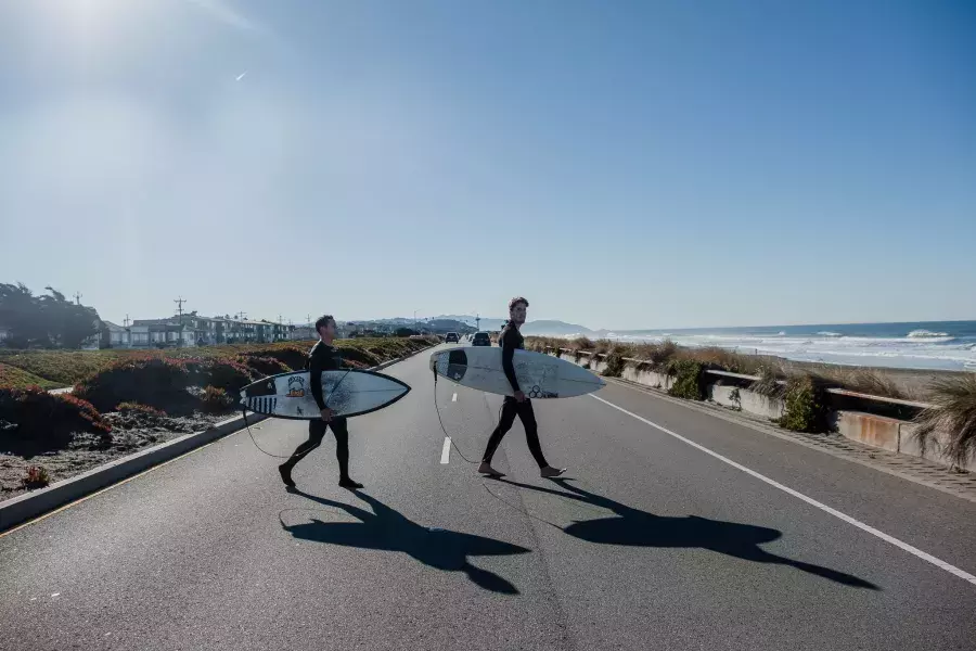 Nick Whittlesey holding a surfboard on the Great Highway.