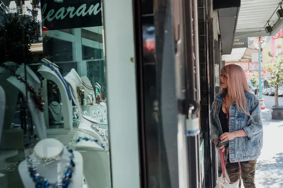 Nya Cruz looking at jewelry through a window.