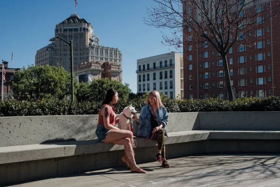 Nya Cruz sitting with a friend and a dog in Nob Hill.