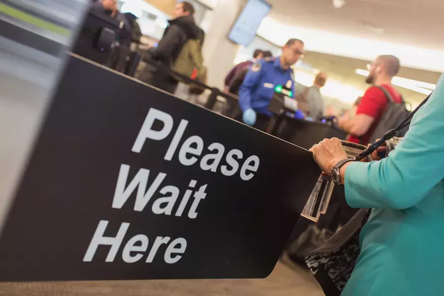 Please wait here sign at SFO security.