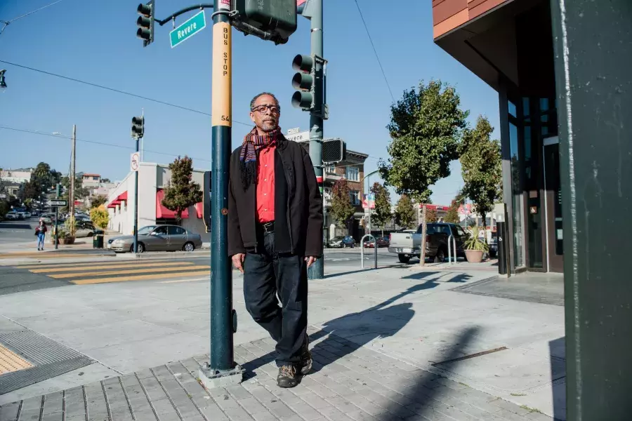 Ron Moultrie Saunders leaning against a pole.