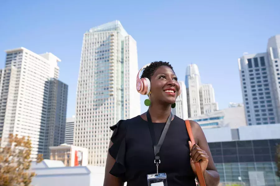 A woman wearing headphones walks through San Francisco's SoMa neighborhood.