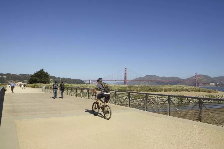 Um homem anda de bicicleta por uma trilha em Crissy Field. São Francisco, Califórnia.