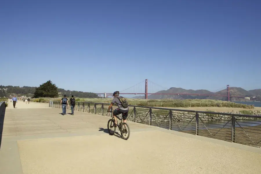 A man rides a bike along a trail at Crissy Field. San Francisco, California.