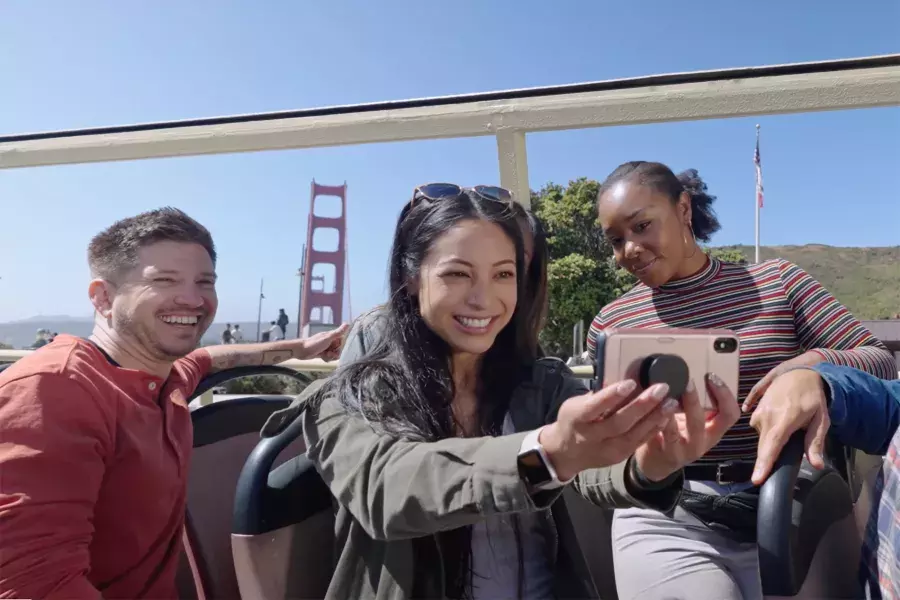 Um grupo de visitantes tira uma selfie em um passeio de ônibus perto da Ponte Golden Gate. São Francisco, Califórnia.