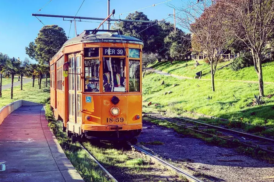 The historic, orange F Line Streetcar rolls down a track in San Francisco's Castro neighborhood.