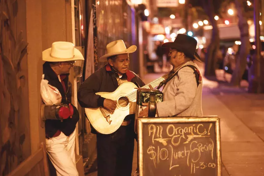 Three Mexican musicians perform on a street in the Mission District of San Francisco.