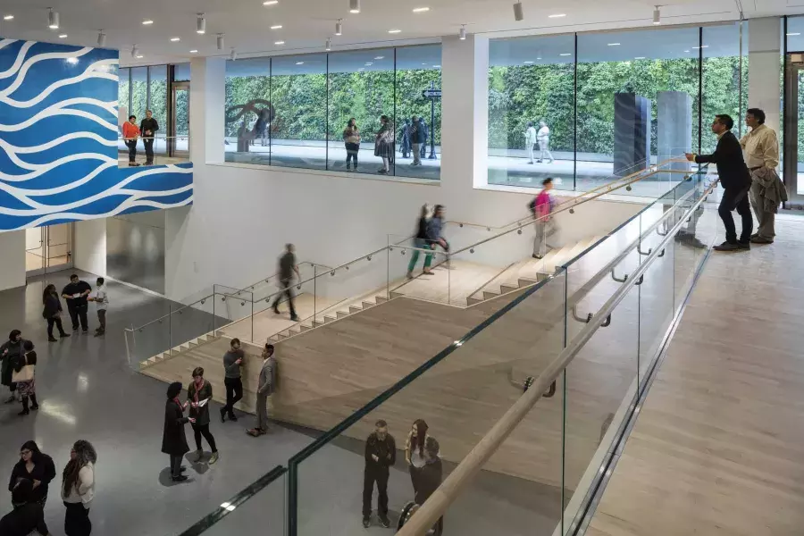 サンフランシスコ近代美術館 (SFMOMA) の広々としたアトリウムで階段を上り下りする人々。