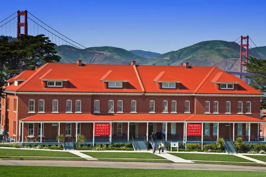 The Walt Disney Family Museum, housed in a row of red-brick former barracks, stands in front of the Golden Gate Bridge. San Francisco, California.