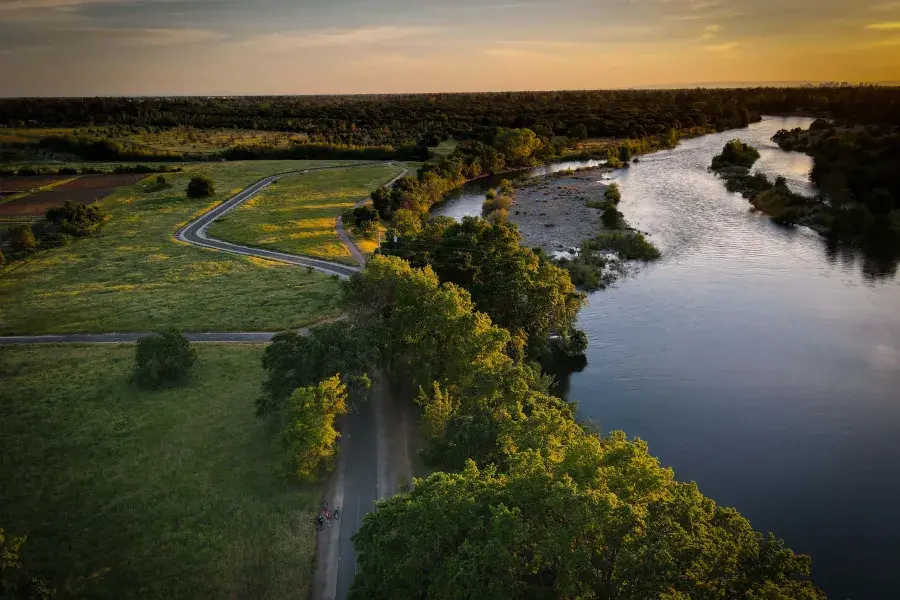 Image of green area and waterway next to it during sun set 