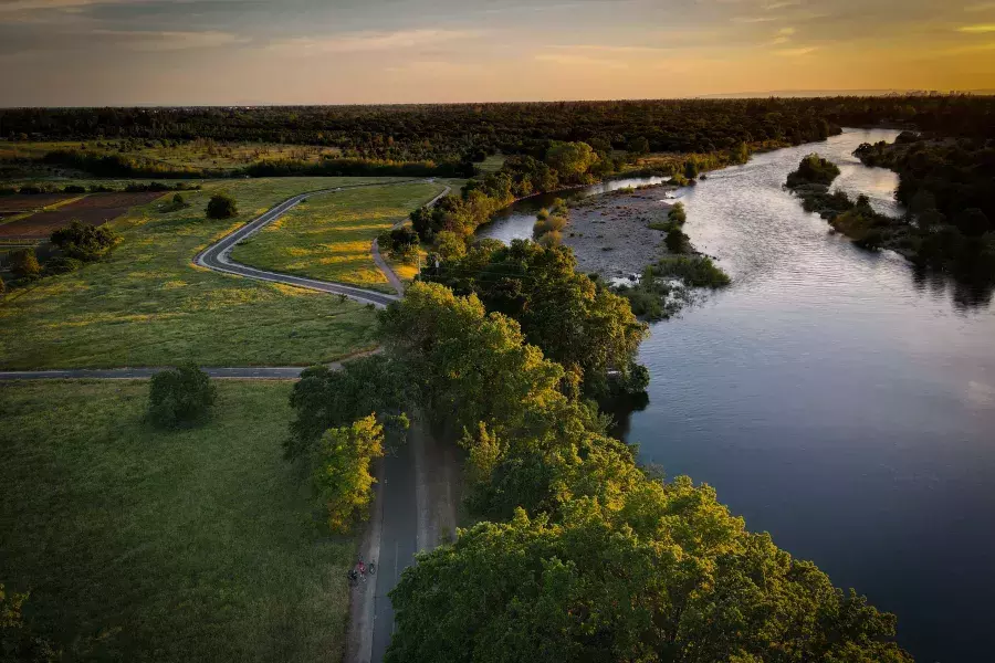 Image of green area and waterway next to it during sun set 