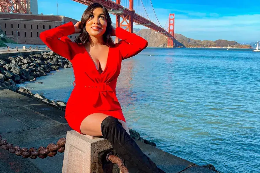 A stylish woman sits at Fort Point near the Golden Gate Bridge.