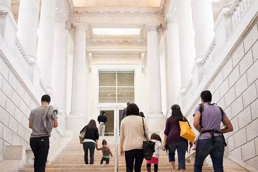 Visitors climb the main staircase of the Asian Art Museum