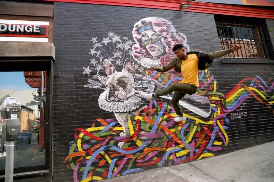 Artist Serge Gay Jr. in front of one of his many murals.