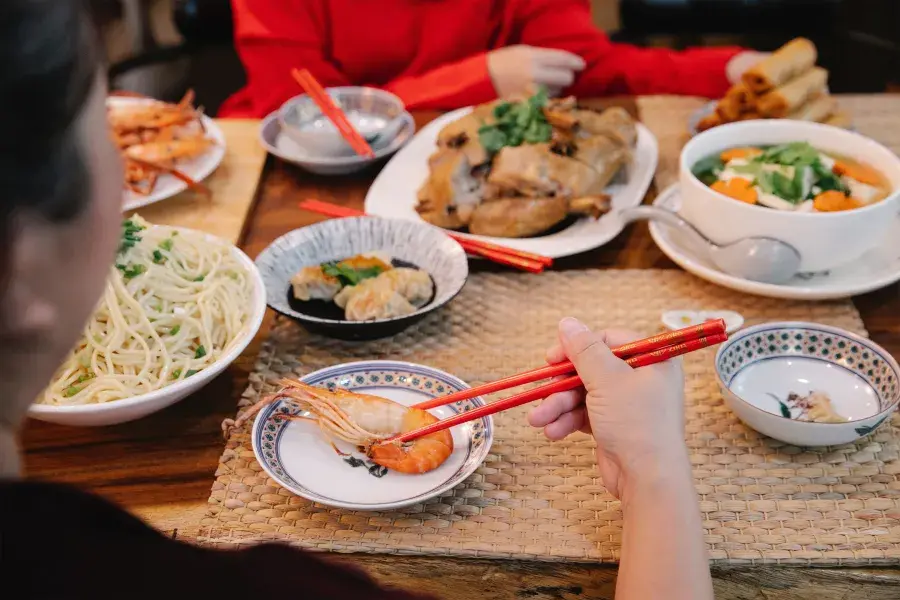 Spread of Chinese food in front of diners at a restaurant