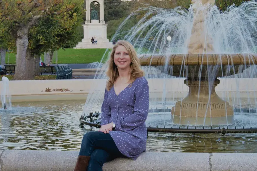 Author Marta Lindsey sits at a fountain in Golden Gate Park's Music Concourse.