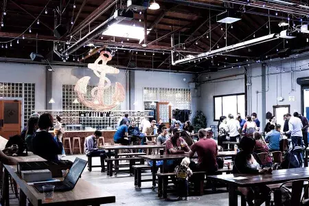 A crowd of people drink beer inside Anchor Public Taps in San Francisco