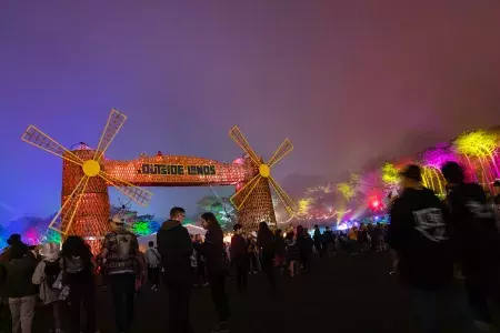 A crowd of festival-goers are pictured at night amid neon lights at the Outside Lands music festival in San Francisco.