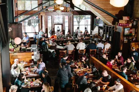 Clientes comem e bebem dentro da 21st Amendment Brewery em São Francisco.