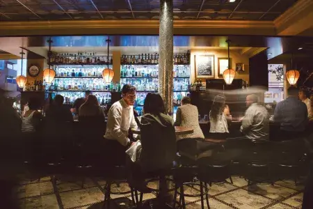 Um casal toma uma bebida em um bar movimentado de São Francisco.