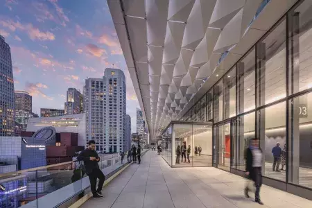 Meeting attendees stand and stroll on a balcony at Moscone Center South in San Francisco.